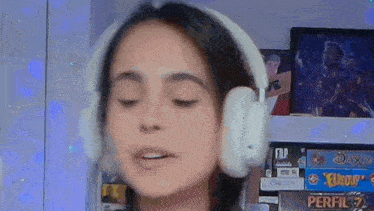 a woman is wearing headphones and making a face .