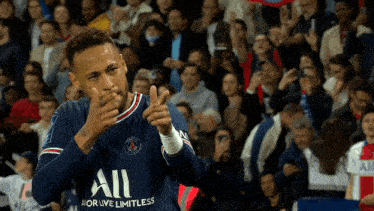 a soccer player is giving a thumbs up sign in front of a crowd during a game .