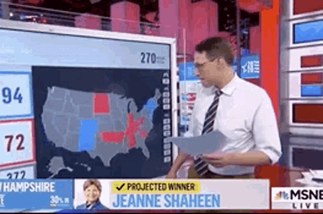 a man standing in front of a screen that says jeanne shaheen