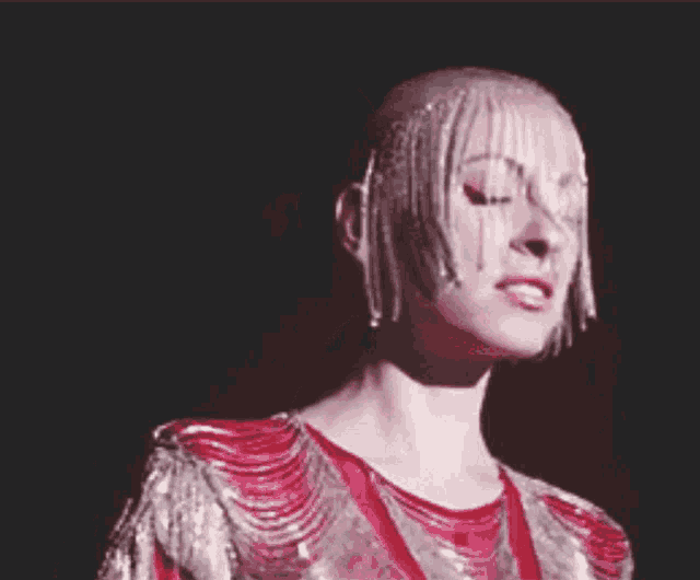 a woman in a red and silver dress with fringe on her head