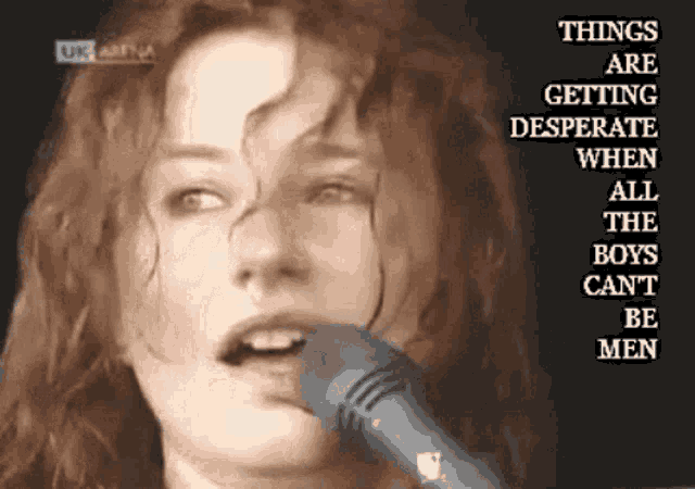 a woman singing into a microphone with the words things are getting desperate when all the boys can 't be men above her