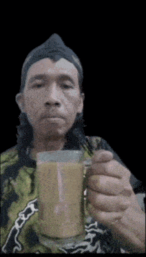 a man holding a cup of coffee with a black background