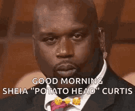 a man in a suit and tie is saying `` good morning sheia `` potato head '' curtis .