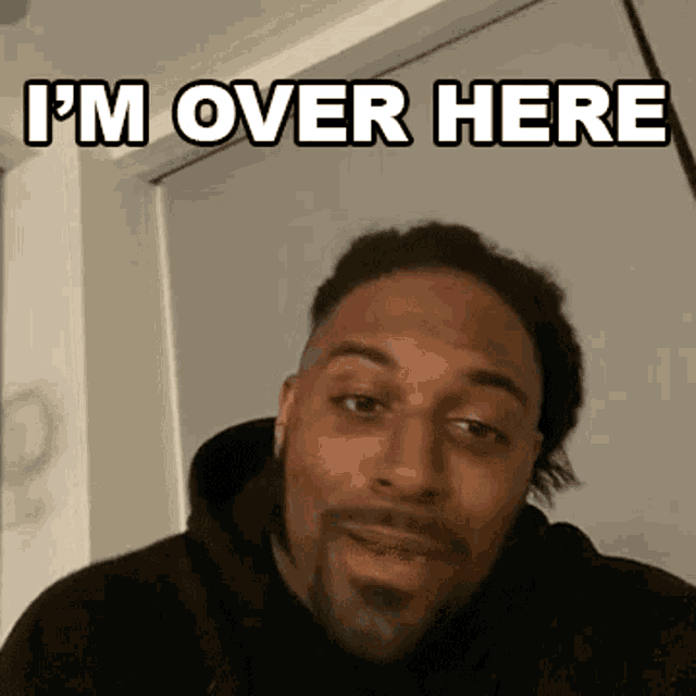 a man with a beard says i 'm over here in front of a door .