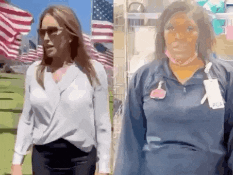 a woman in a white shirt and a woman in a blue shirt are walking next to each other in front of american flags .