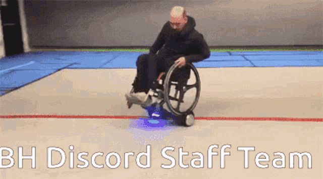 a man in a wheelchair with bh discord staff team below him