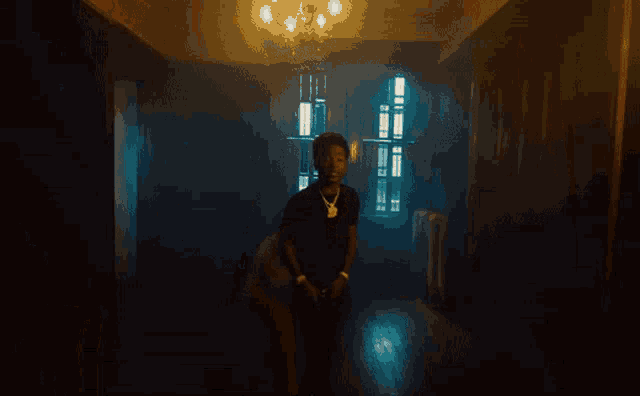 a man in a black shirt is walking through a dark room