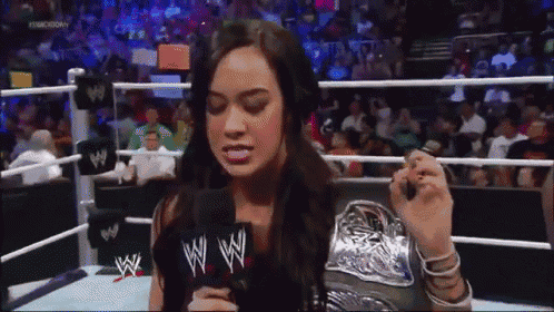 a woman in a wrestling ring with a microphone that says wwe
