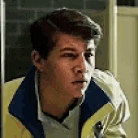 a close up of a man wearing a yellow and blue jacket .