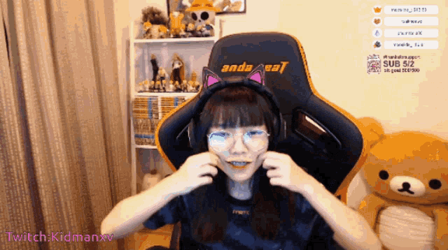 a girl wearing headphones and a cat ear headband is sitting in a chair with the words anda cat on the back