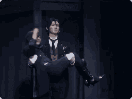 a man in a suit and tie is carrying another man on his shoulders on a stage .
