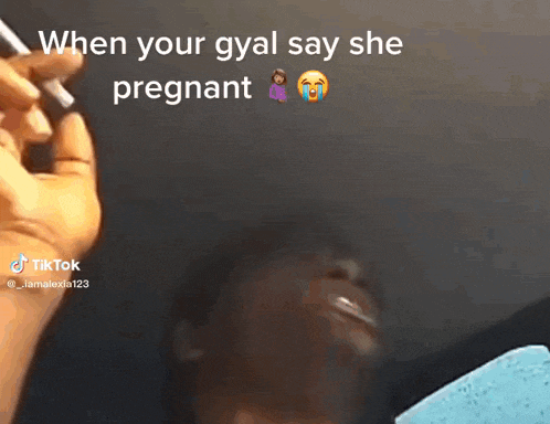 a person smoking a cigarette with a caption that says when your gyal say she pregnant
