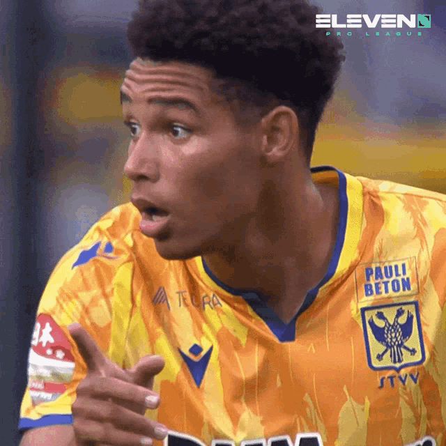 a soccer player wearing a yellow and blue jersey with pauli beton on it