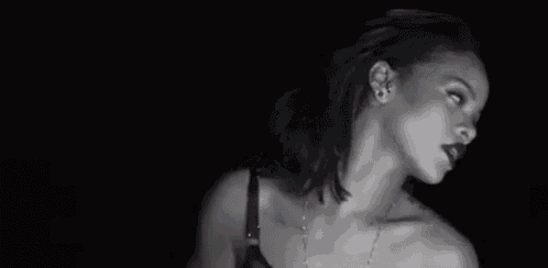 a black and white photo of a woman wearing a bra and a necklace .