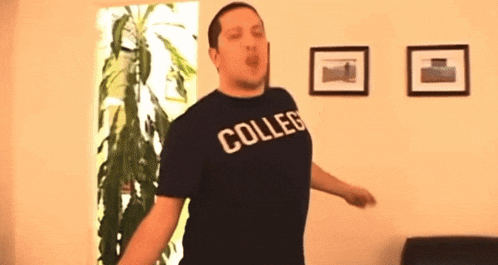 a man wearing a collegiate t-shirt is dancing