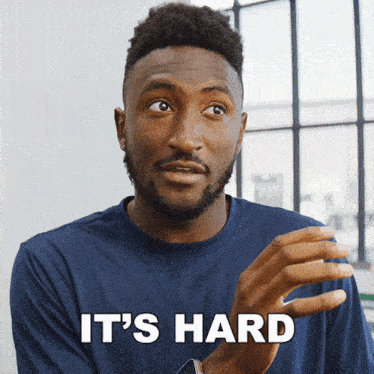 a man in a blue shirt says it 's hard in white letters