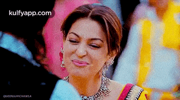 a close up of a woman making a funny face while holding a piece of cotton candy .