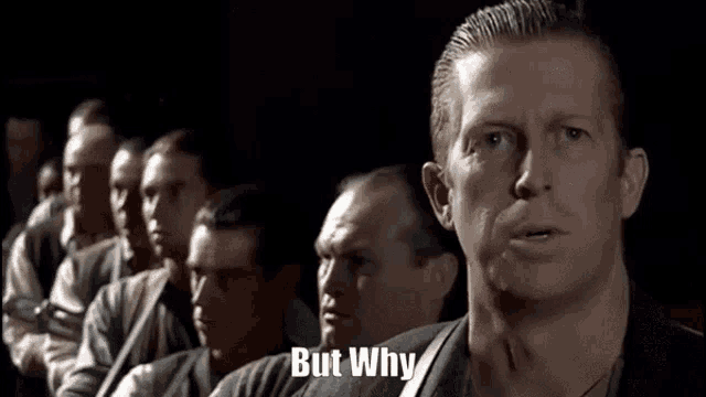 a group of men are sitting in a row and one of them is asking why .