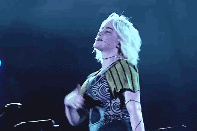 a woman with blonde hair is standing on a stage