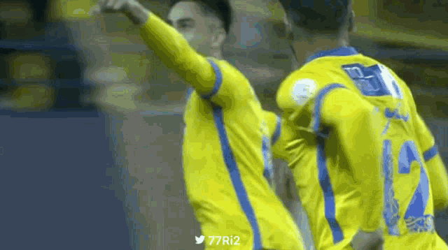 two soccer players are celebrating a goal with the hashtag 77ri2 in the corner