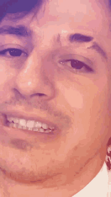 a close up of a man 's face with a smile