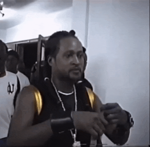 a man wearing a white shirt with the letter u on the front
