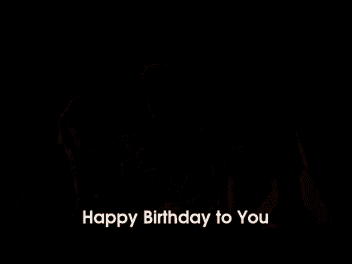 a group of people are standing next to each other and one of them is saying happy birthday to you .