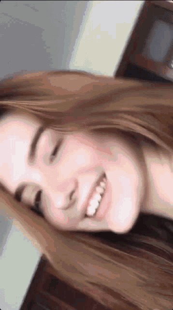 a close up of a woman 's face with her eyes closed and smiling
