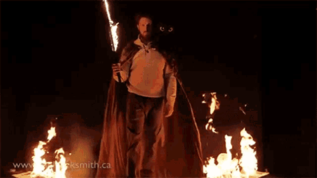 a man in a cape is standing in front of a fire with the website www.rocksmith.ca visible