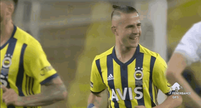 a soccer player wearing a yellow and blue jersey with avis on it
