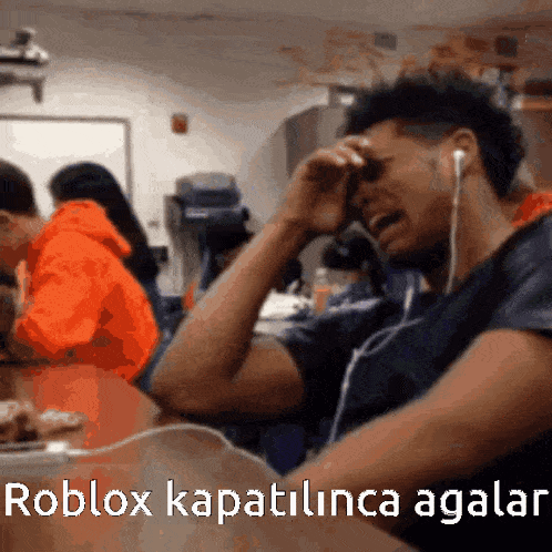 a man wearing ear buds is crying in a classroom with the words roblox kapatilunca agallar written on the bottom