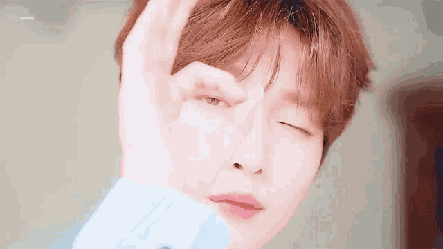a close up of a person 's face with their hand on it .