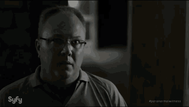 a man with glasses and a syfy logo on his shirt