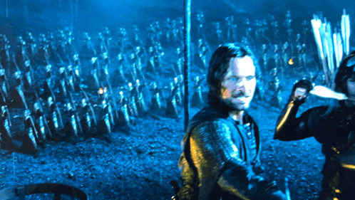 a man stands in front of a crowd of soldiers holding swords