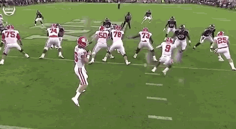 a group of football players are playing a game on a field in a stadium .