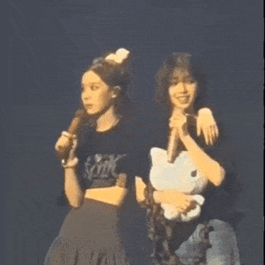 a couple of women standing next to each other on a stage .