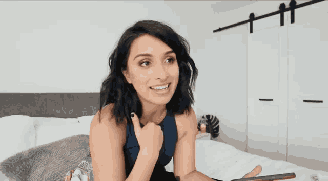 a woman laying on a bed with a thumbs up