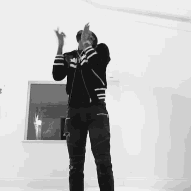 a black and white photo of a man in a striped jacket dancing