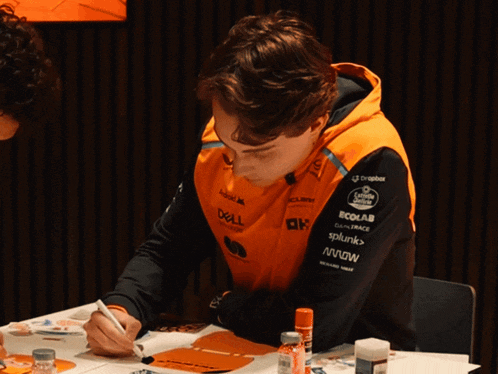 a man sitting at a table with a dell sweatshirt on
