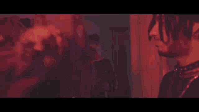 a group of young men are standing next to each other in a dark room with a pentagram in the background .