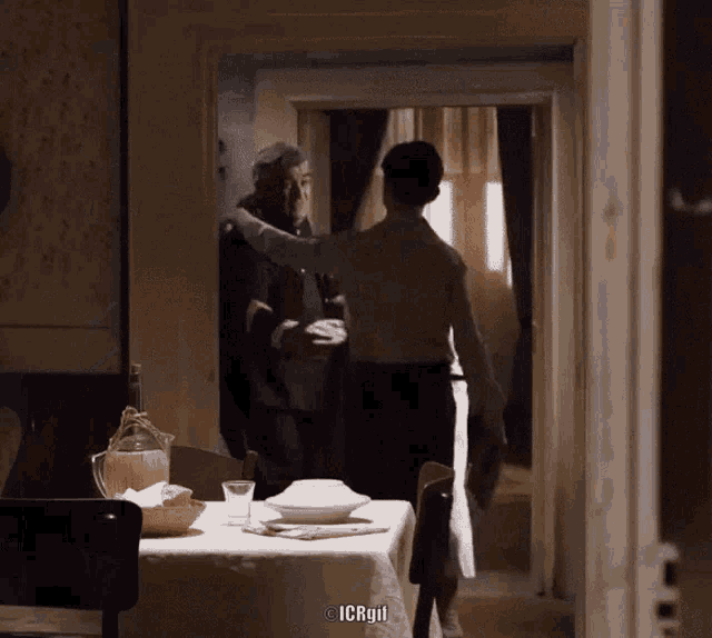 a man and woman are standing in front of a table with a watermark of icrgyl