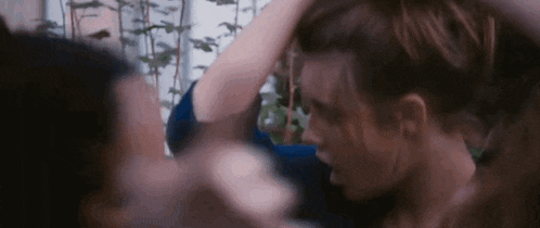 a woman is holding another woman 's hair in a close up of a movie scene .