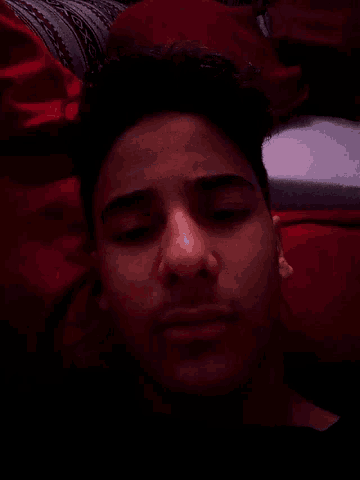 a man laying on a bed with his eyes closed
