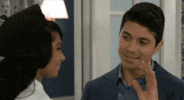 a man in a suit and a woman in a beret are looking at each other