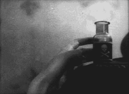 a person holding a bottle with a skull and crossbones on it