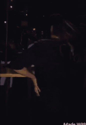 a man in a black shirt is dancing in a dark room with the words made with written on the bottom