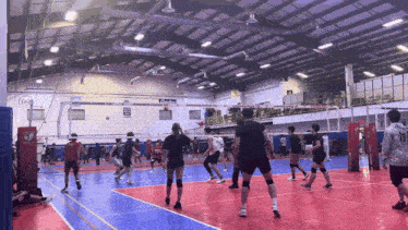 a group of people are playing volleyball in a gym with the number 19 on the back of the jersey