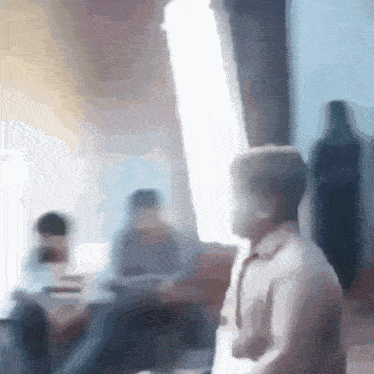 a blurry picture of a man holding a lightsaber in a room .