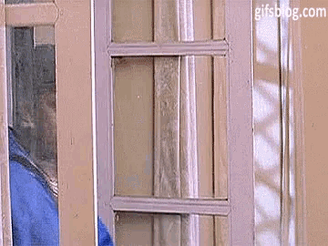 a person is standing in front of a window looking out .