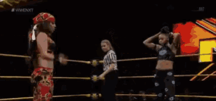 a wrestler is laying on the ground in a wrestling ring